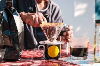 İnsanlar sabahları evdeki açık hava masasında filtrelenmiş kahve damlalarıyla konuşuyorlar.