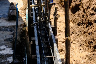 Deforme olmuş demir kiriş, anket sonucu duvar inşaatı üzerinde çalışıyor.