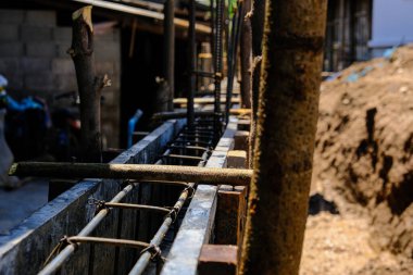 Deforme olmuş demir kiriş, anket sonucu duvar inşaatı üzerinde çalışıyor.