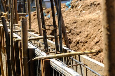 Deforme olmuş demir kiriş, anket sonucu duvar inşaatı üzerinde çalışıyor.