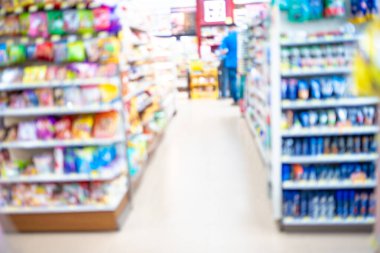 Süpermarketin arka planında rafta çeşitli yiyecek ve içecekler bulanıklaştı