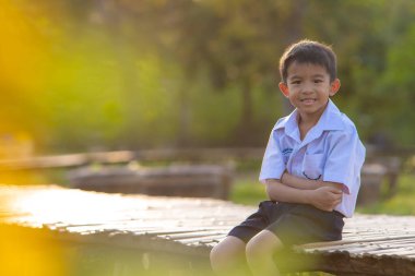 Asyalı okul çocuğu, şehir parkında rahatla, gün batımı, gün batımı, şehir çocuğu.
