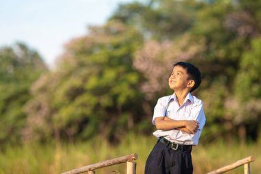 Asyalı okul çocuğu, şehir parkında rahatla, gün batımı, gün batımı, şehir çocuğu.