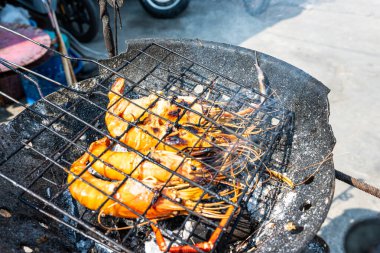 Büyük nehir karidesi ateşte kızartılmış deniz mahsulü yemeğiyle.