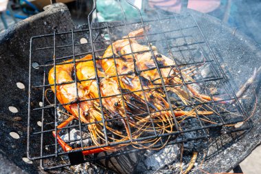 Büyük nehir karidesi ateşte kızartılmış deniz mahsulü yemeğiyle.