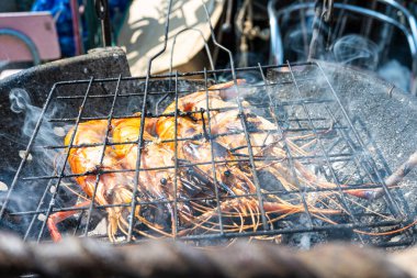 Büyük nehir karidesi ateşte kızartılmış deniz mahsulü yemeğiyle.