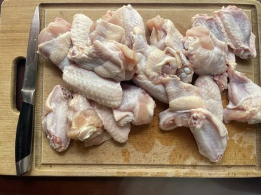 Tavuk kanadı. Kümes hayvanları. Yemek pişirmek. Siyah arka planda ahşap bir kasede tavuk kanatları 