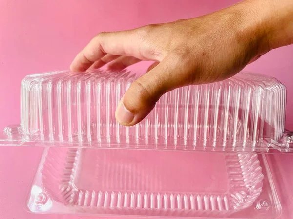 Plastic container . Food container. Disposable plastic container. Takeaway food. .a woman 's hands holding a transparent tray with white plastic box.