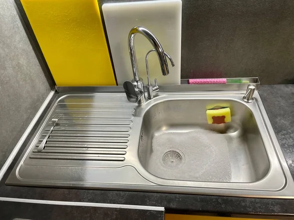 厨房的水槽 厨房水龙头Kitchen Faucet Dostochka的切片 厨房的内部 厨房用黄色毛巾 水槽上有水龙头和海绵 — 图库照片