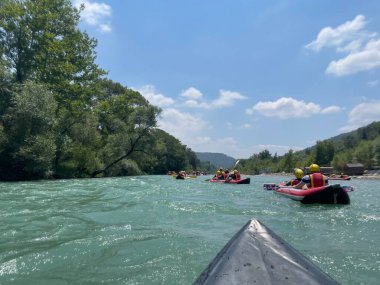 Dağlardaki nehirde bir grup insan.