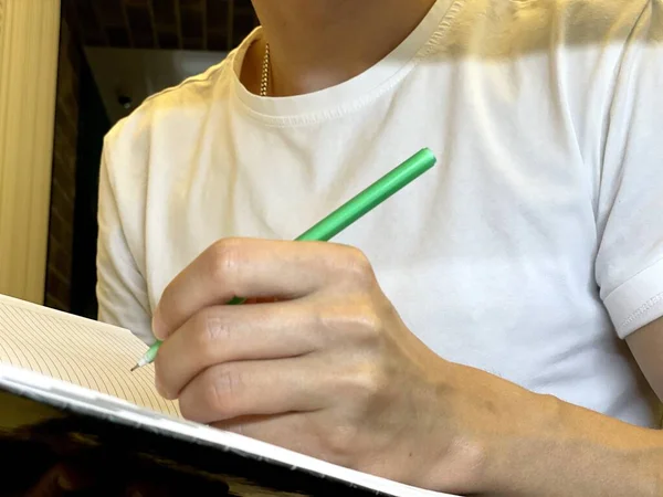 用钢笔在笔记本上写字的人 在笔记本上写字的年轻人 — 图库照片