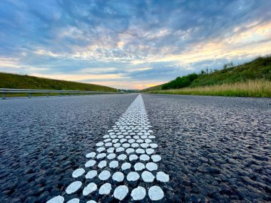 Yol. Gün batımında yol. Otoyol. Ayrılma şeridi yolda. Yolun güzel manzarası.