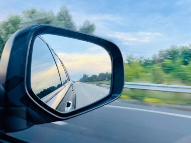 Araba yollarda. Dikiz aynası. Araba hareket halinde. Araba geçiyor. Otoyol. Araba hareket halinde..