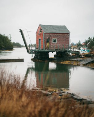 Blue Rocks, Nova Scotia, Kanada 'da bulutlu bir sabahta kırmızı bir balıkçı kulübesi.