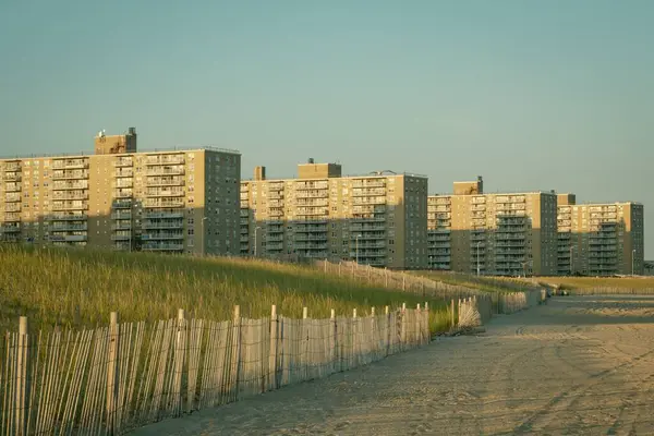 Çimenli kum tepeleri ve Rockaway Sahili, Queens, New York manzaralı binalar.