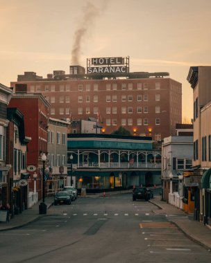 View of the Hotel Saranac at sunrise in downtown Saranac Lake, New York clipart