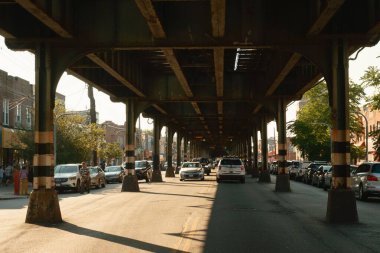 Street scene under elevated D train tracks in Brooklyn, New York clipart