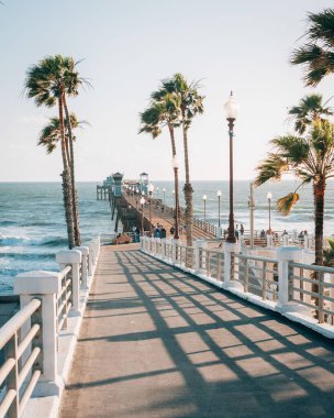 Okyanus side, San Diego County, Kaliforniya'da, Pasifik Okyanusu'na bakan iskele ve palmiye ağaçlarına rampa