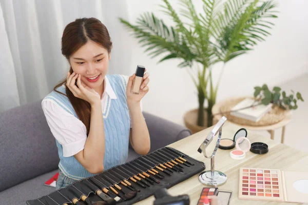 Beauty blogger concept, Young Asian woman recommend concealer to subscribers in live streaming.