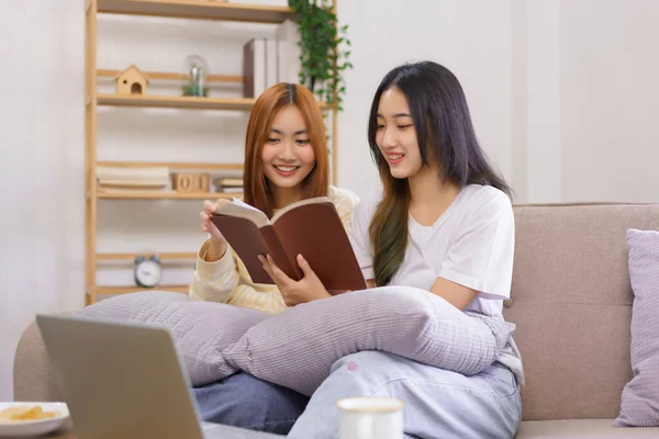 Activity at home concept, LGBT lesbian couple reads and learning holy bible together in living room.
