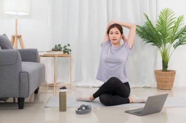 Yoga exercise concept, Young Asian woman stretching and doing yoga exercise training online at home.