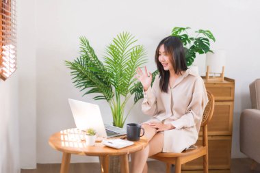 Oturma odasında faaliyet kavramı, Asyalı kadın arkadaşlarıyla selamlaşma jesti yapıyor..