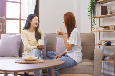 Ev konseptinde faaliyet, LGBT lezbiyen koltukta oturup kahve içerken birlikte konuşmak..