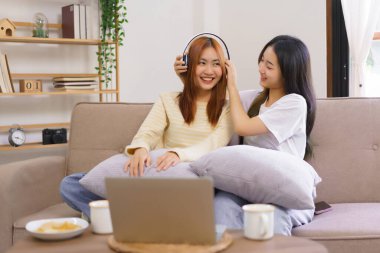 Evde rahatla, lezbiyen çift kulaklık takıyor ve birlikte müzik dinliyorlar..