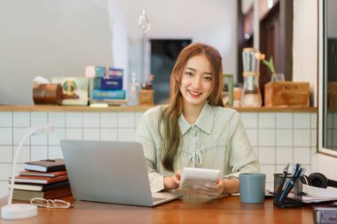Ortak çalışan uzay ofisi kavramı, kadın girişimci proje bütçesini hesaplamak için hesap makinesi kullanıyor.