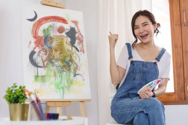Sanat konsepti. Genç Asyalı kadın sanat şaheserlerini çizdikten sonra mutlu..