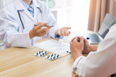 Bir doktor konseptini ziyaret ediyor. Bir erkek doktor hastasıyla tedavi konusunda emin oluyor ve ona rahatlatıcı bir jest yapıyor. 