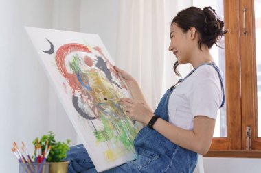 Sanat yaratıcılığı, genç Asyalı kadın resim çizmek için stüdyoda oturuyor..