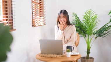 Rahatlama yaşam tarzı konsepti, genç Asyalı kadın arkadaşlarıyla görüntülü konuşma yaparken gülüyor..