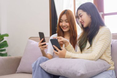 Ev konseptinde etkinlik, LGBT lezbiyen çifti internetten alışveriş yaparken akıllı telefonlara bakıyorlar..