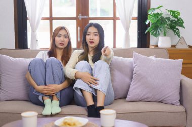 Ev kavramındaki etkinlik, LGBT lezbiyen çifti korku ve film izlerken ekranı işaret ediyor.