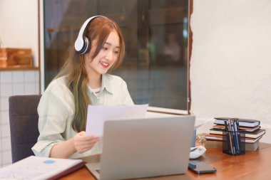Ortak çalışan uzay ofisi kavramı, kadın girişimci video görüşmesi ve belge okuma üzerine toplanıyor.