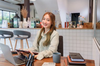 Uzaktan çalışma konsepti, dizüstü bilgisayarda çalışan ve ortak çalışma alanında belge yazan kadın girişimci.