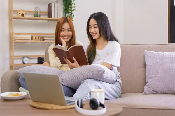 Relax at home concept, LGBT lesbian couple reading and learning holy bible together in living room.