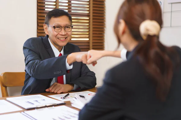 Business analysis concept, Senior business and businesswoman making fist bump after work successful.