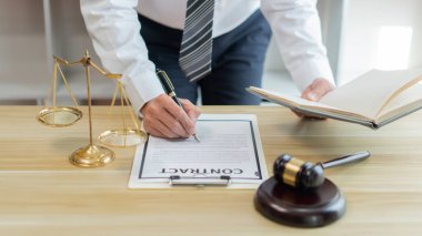 Hukuk danışmanlığı kavramı. Bir erkek avukat, sözleşmeye kendi başına daha net bir açıklama ekleyerek bazı detayları açıklığa kavuşturuyor.  