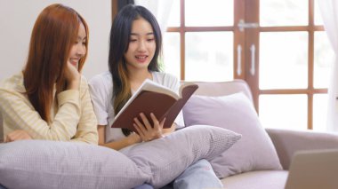 Ev konseptinde faaliyet, LGBT lezbiyen çifti oturma odasında kutsal İncil 'i birlikte okuyup öğreniyorlar..