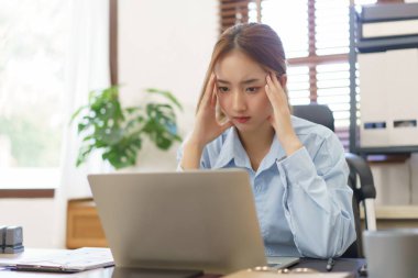 Business concept, Businesswomen stressful while reading financial report on laptop at workplace.