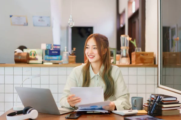 Business concept, Woman entrepreneur holding document and looking outside in coworking space office.
