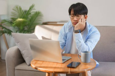 Business lifestyle, Businessman resting chin on hand with bored and tired while working on laptop.