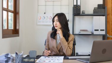 Sekreter konsepti, kadın sekreter ofiste çalışırken dışarıya bakıp bir şeyler düşünüyor..