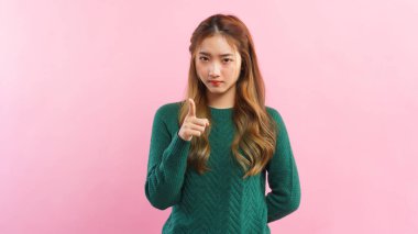 Memnuniyetsizlikle işaret eden genç kadın ve pembe arka planda izole edilmiş kızgın yüz..