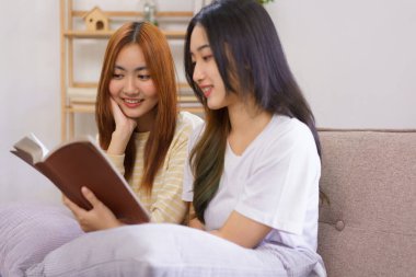 Ev konseptinde faaliyet, LGBT lezbiyen çifti oturma odasında kutsal İncil 'i birlikte okuyup öğreniyorlar..