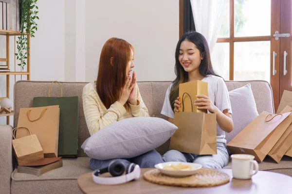 Relax at home concept, LGBT lesbian female shocked face while receiving gift box from girlfriend.