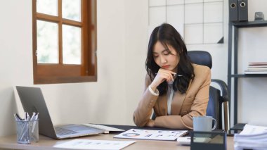 Sekreter konsepti, kadın sekreter iş belgesini okuyor ve finans verilerini düşünüyor.