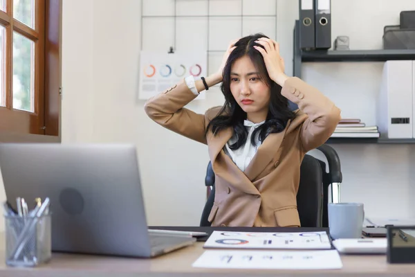 Secretary concept, Female secretary put hands on head while stressed out from reading email of boss.